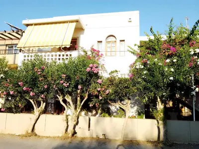 a white building with trees in front of it at Irini Apartments in Plataniás