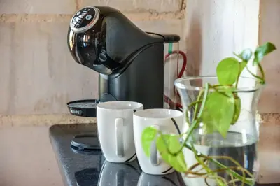 a coffee maker sitting on a counter with two cups at World Villa in Tavronitis
