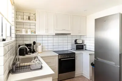 a kitchen with white cabinets and a black dishwasher at Dream Casa by the Sea by 8essentially in Chania Town