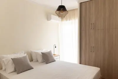 a bedroom with a bed with white sheets and a window at Dream Casa by the Sea by 8essentially in Chania Town