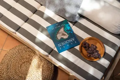 a book sitting on top of a couch with a bowl of food at Orion Chania Boutique City House in Chania Town