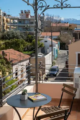 a table and chairs on a balcony with a view of a city at Orion Chania Boutique City House in Chania Town