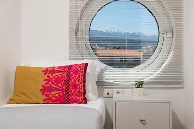 a bedroom with a window and a bed with a pillow at Orion Chania Boutique City House in Chania Town