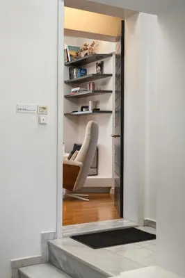 a view into a living room with a chair through a doorway at Orion Chania Boutique City House in Chania Town
