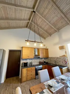 a kitchen with a table with chairs and a dining room at Villa Eftychia Serene Getaway with Hot Tub in a Quiet Location in Kissamos