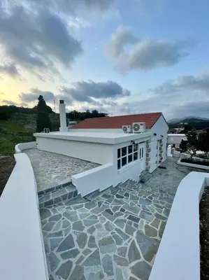 a white house with a stone walkway in front at Villa Eftychia Serene Getaway with Hot Tub in a Quiet Location in Kissamos