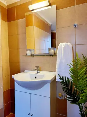 a bathroom with a white sink and a mirror at Mariviky design apartment in Chania Town