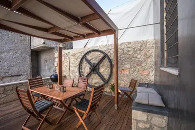 a wooden table and chairs on a wooden deck at Villa Yasemi panoramic sea view in Chania Town