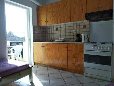 a kitchen with wooden cabinets and a stove top oven at Ton Mari Apartments in Palaiochóra