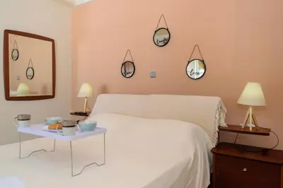 a bedroom with a white bed and four clocks on the wall at Central penthouse in quiet neighborhood near sandy beach in Chania Town