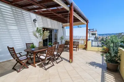 a patio with a table and chairs on a balcony at Central penthouse in quiet neighborhood near sandy beach in Chania Town