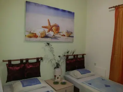 a room with two beds and a picture on the wall at VILLA ANNA in Ravdhoúkha