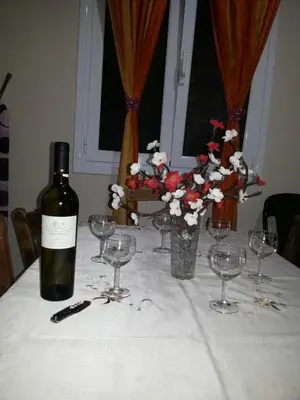 a bottle of wine sitting on a table with wine glasses at VILLA ANNA in Ravdhoúkha