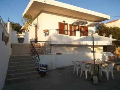a small white house with a table and chairs at VILLA ANNA in Ravdhoúkha