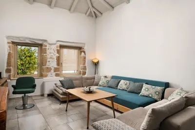 a living room with a couch and a table at Mansion D in Galatás