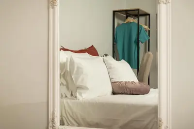 a mirror with a white couch in front of a blue shirt at Mansion D in Galatás