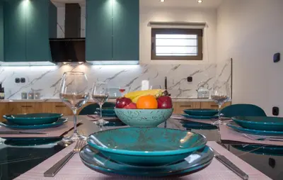 a table with a bowl of fruit and wine glasses at Anastasia & Maria Luxury Residence in Kissamos