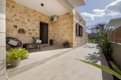 an outdoor patio with stone walls and plants at Anastasia & Maria Luxury Residence in Kissamos
