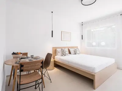 a bedroom with a bed and a table and a table and chairs at Astra boutique suites at Agia Marina Beach in Agia Marina Nea Kydonias