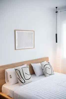 a bedroom with a bed with white sheets and pillows at Astra boutique suites at Agia Marina Beach in Agia Marina Nea Kydonias