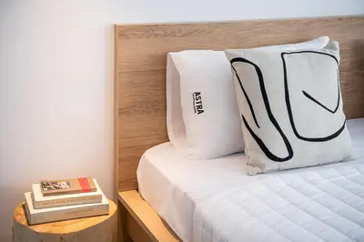 a bedroom with a bed with a pillow and a book at Astra boutique suites at Agia Marina Beach in Agia Marina Nea Kydonias