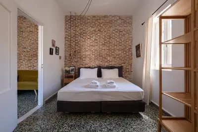 a bedroom with a bed and a brick wall at MV Living - Residence in Chania Town