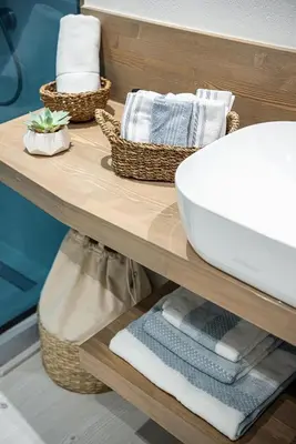 a bathroom with a sink and towels on a shelf at Villaspo Homes in Chania Town