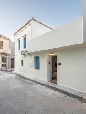 a white house with a blue door at Villaspo Homes in Chania Town