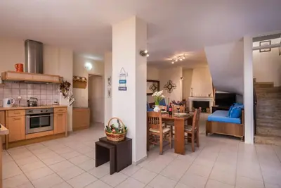 a kitchen and living room with a table and a blue couch at Seaview Villa Sofia ' Top destination ' in Kissamos