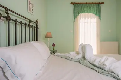 a bed with white sheets and pillows and a window at Seaview Villa Sofia ' Top destination ' in Kissamos