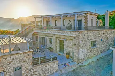 a stone house with a roof with a patio at Petros Luxury Traditional House - Villa in Kissamos