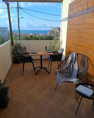 a table and chairs on a patio with a view of the ocean at GioDriana cozy studio in Agia Marina Nea Kydonias