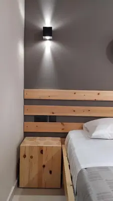 a bedroom with a bed and a light on the wall at GioDriana cozy studio in Agia Marina Nea Kydonias