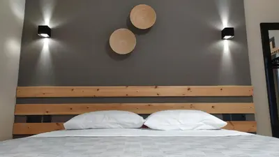 a bed with two pillows and two hats on the wall at GioDriana cozy studio in Agia Marina Nea Kydonias