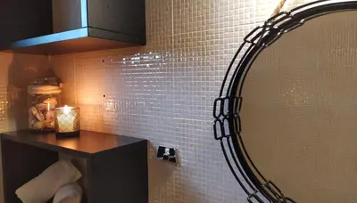 a bathroom with a mirror and a black counter at GioDriana cozy studio in Agia Marina Nea Kydonias