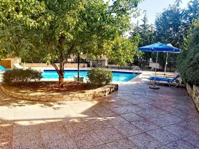 a swimming pool with a tree and a blue umbrella at Retreat Homes Apokoronas in Douliana