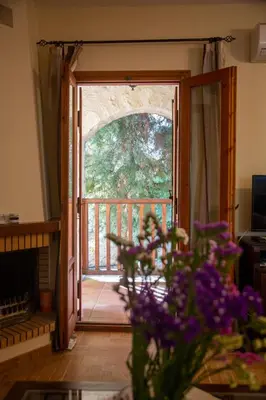 an open door to a porch with purple flowers at Retreat Homes Apokoronas in Douliana