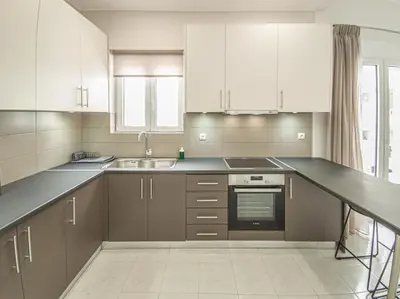 a kitchen with white cabinets and a sink at Fully renovated apartment in the city centre with roof garden! 3 minutes from the bus station and 6 minutes from the old town in Chania Town