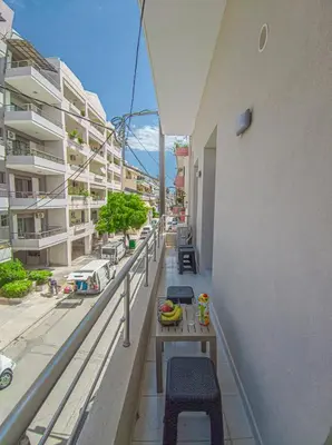 a balcony with chairs and a table on a building at Fully renovated apartment in the city centre with roof garden! 3 minutes from the bus station and 6 minutes from the old town in Chania Town