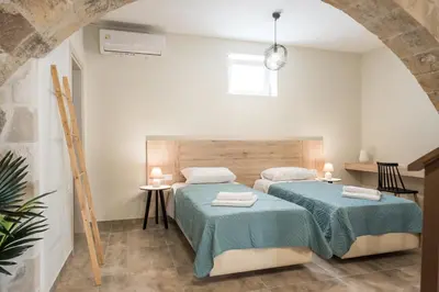 two beds in a room with white walls at Dinas's Cottage Ideal Base for Balos and Elafonisi in Kaloudhianá