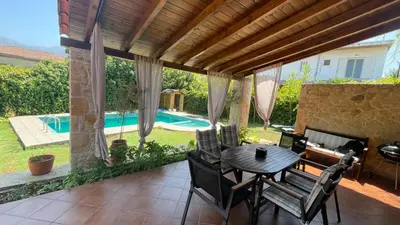 a patio with a table and chairs and a pool at Skine Dream Villa in Chania Town