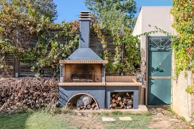 a wood fired oven sitting next to a building at Skine Dream Villa in Chania Town