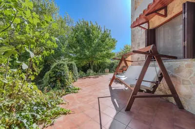 a porch with a swinging chair on a patio at Skine Dream Villa in Chania Town