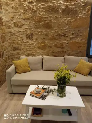 a living room with a couch and a table at nafsikacottagehouse in Kissamos
