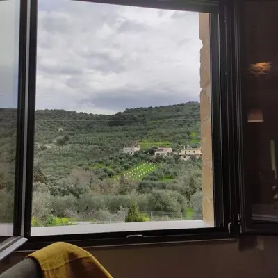 a window with a view of a vineyard seen through it at nafsikacottagehouse in Kissamos