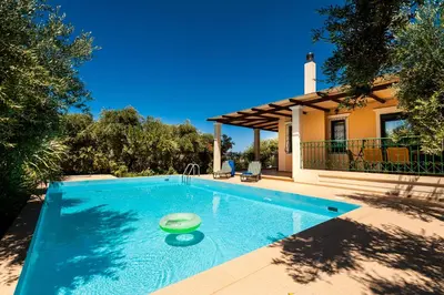 a swimming pool with a frisbee in front of a house at Villa Vallia - Villa Marina in Kato Galatas