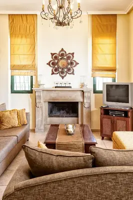 a living room with a couch and a fireplace at Villa Vallia - Villa Marina in Kato Galatas