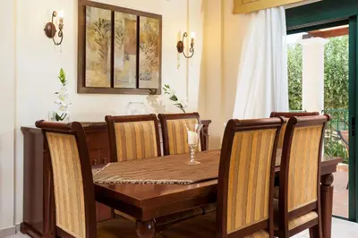 a dining room with a wooden table and chairs at Villa Vallia - Villa Marina in Kato Galatas