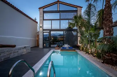 a swimming pool in a house with a large window at Villa Armenus, private pool, garden, BBQ in Chania Town