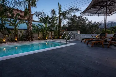 a swimming pool in a backyard with a table and benches at Villa Armenus, private pool, garden, BBQ in Chania Town